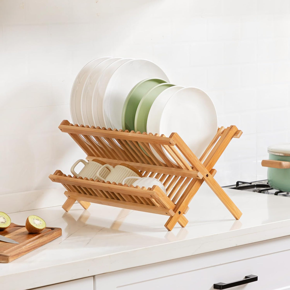 Wooden dish rack with plates and mugs on a kitchen counter