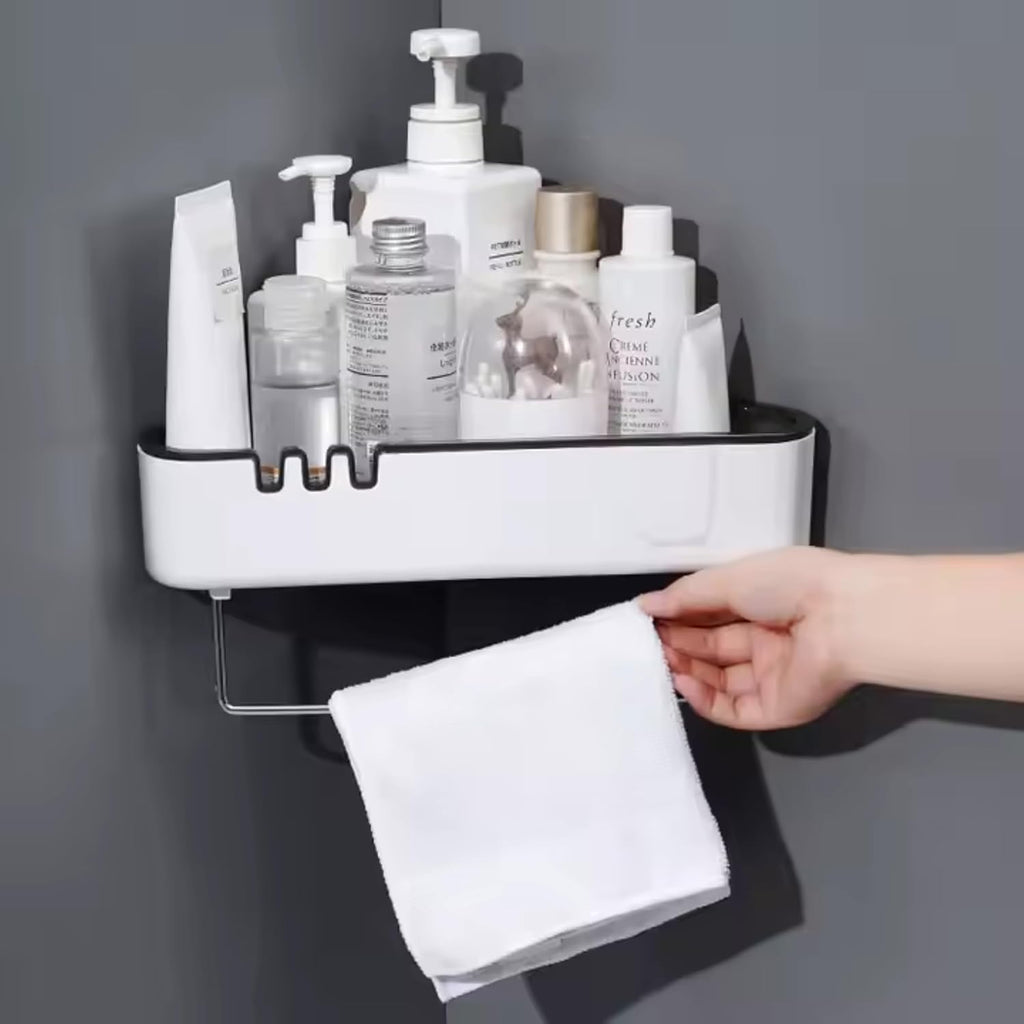 White wall-mounted shelf with skincare products and a hand holding a towel against a gray background