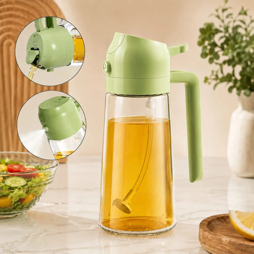 A light green and clear glass oil dispenser pitcher filled with golden oil, shown on a kitchen counter with two circular inset close-ups of the spout and pour mechanism. A salad bowl, lemon slice, and vase of greenery are softly blurred in the background.