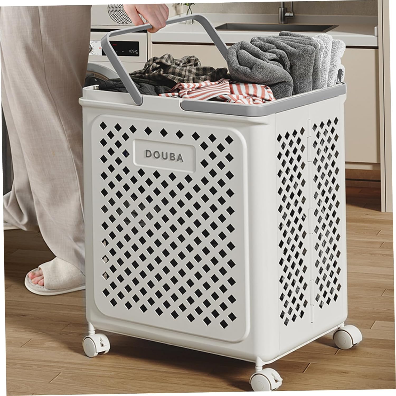 Person pushing a laundry basket filled with clothes in a kitchen.