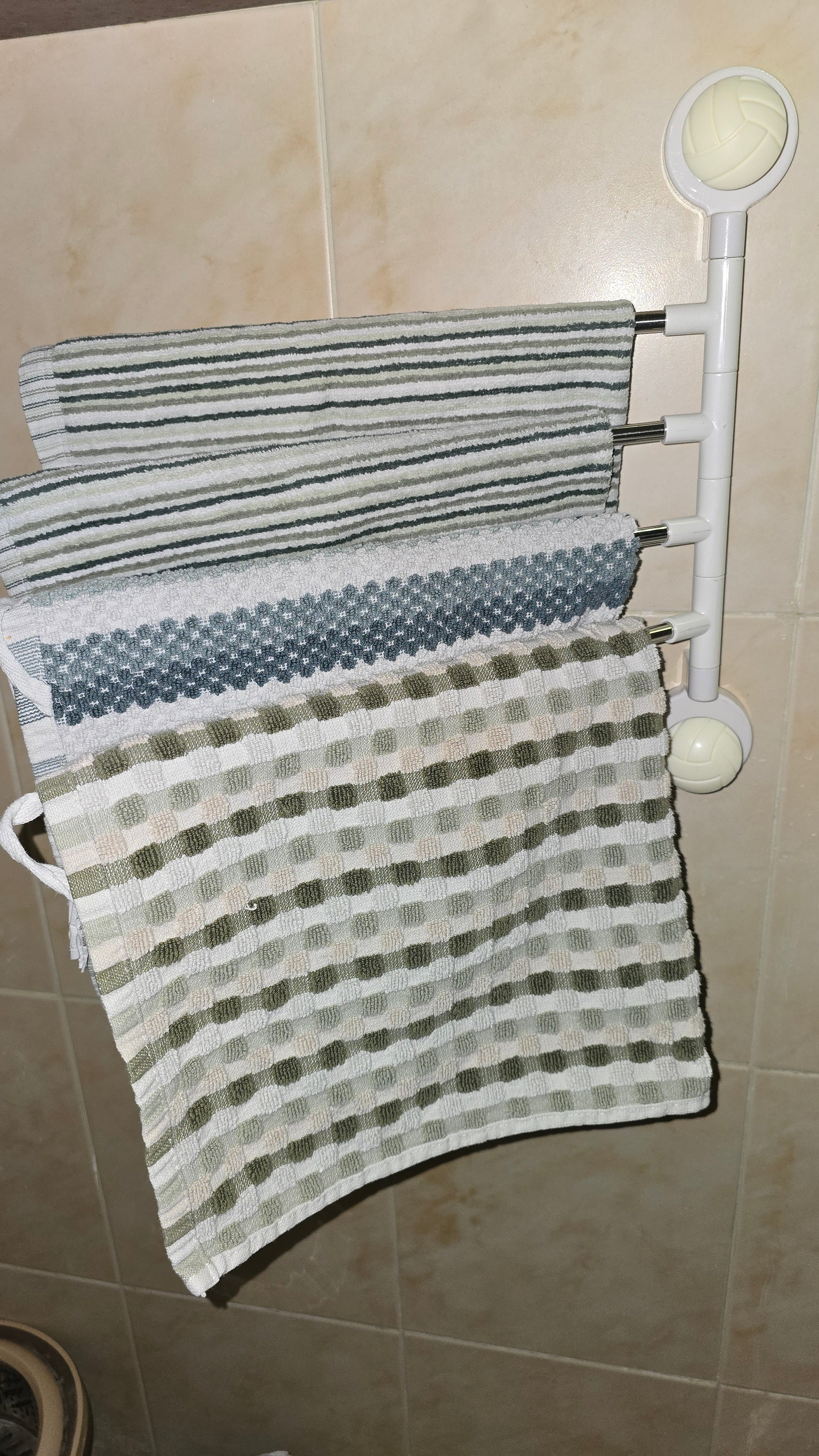 Beiryta four-arm rotating no-drill towel rack installed on bathroom tiles with towels
