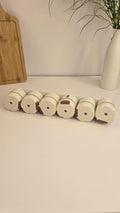 Beiryta six-piece magnetic spice dispenser set arranged on its mounting strip