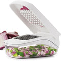White vegetable chopper with chopped vegetables and whole onions on a white background