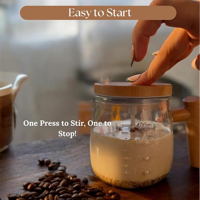 A clear glass coffee maker with a wooden lid and handle sits on a wooden table, with a hand pressing the lid to stir a light-colored liquid inside. White text overlays read 'Easy to Start' and 'One Press to Stir, One to Stop!'.