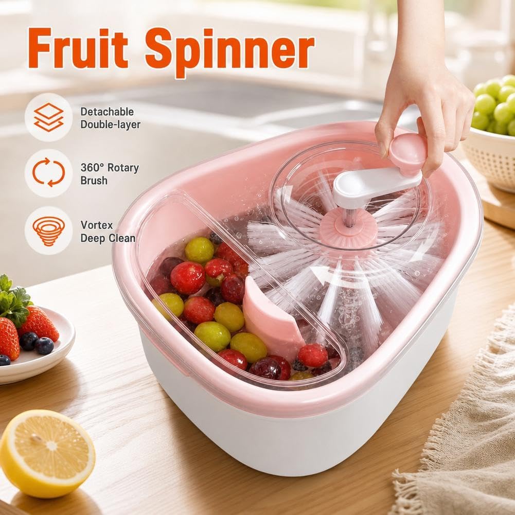 A pink and white fruit spinner bowl shown on a kitchen counter with fruit inside, a hand turning the top handle, and marketing text reading 'Fruit Spinner' plus feature icons.