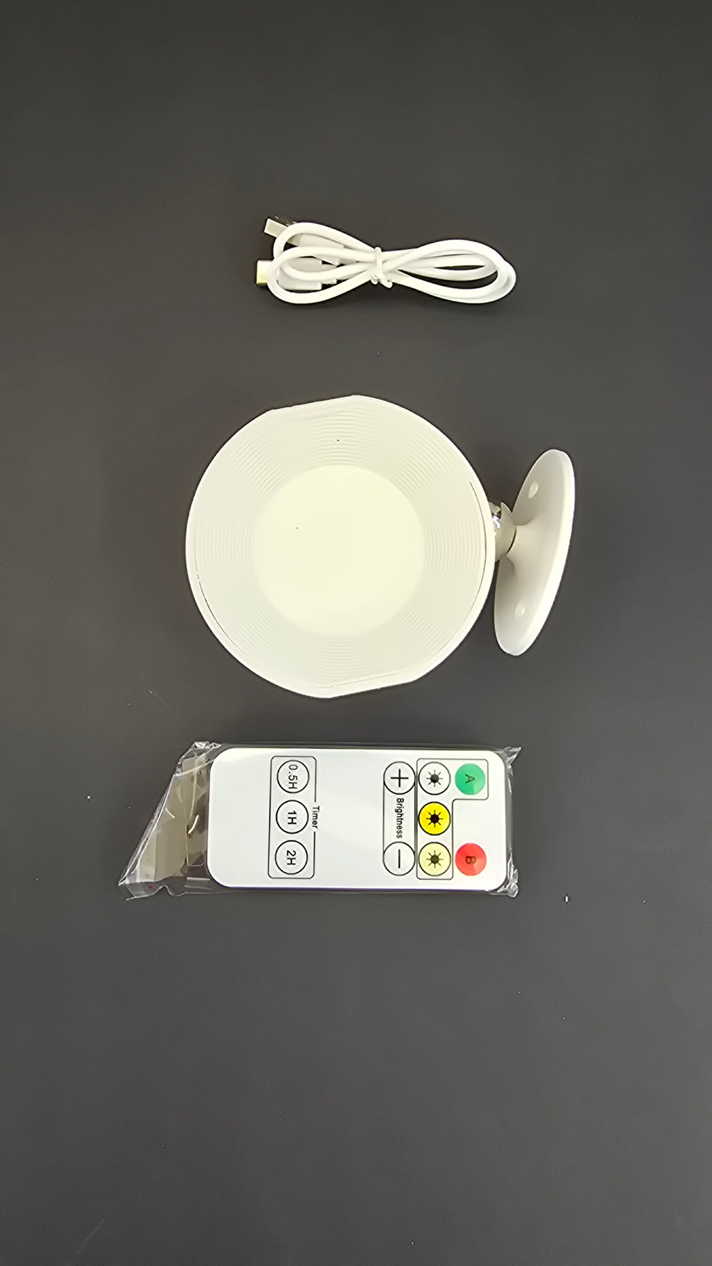 Top view of the rechargeable LED wall light, remote control and USB charging cable