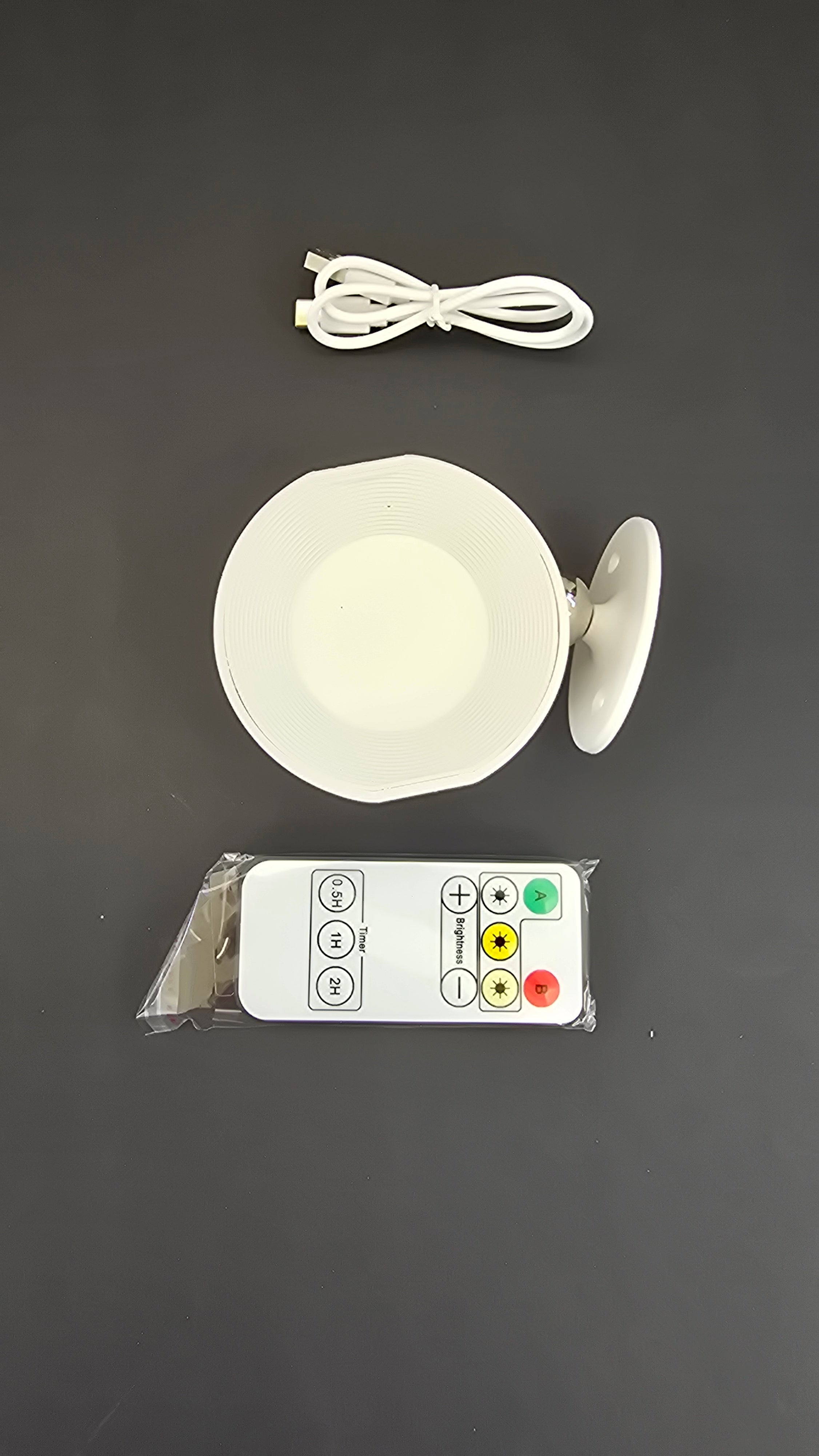 Top view of the rechargeable LED wall light, remote control and USB charging cable