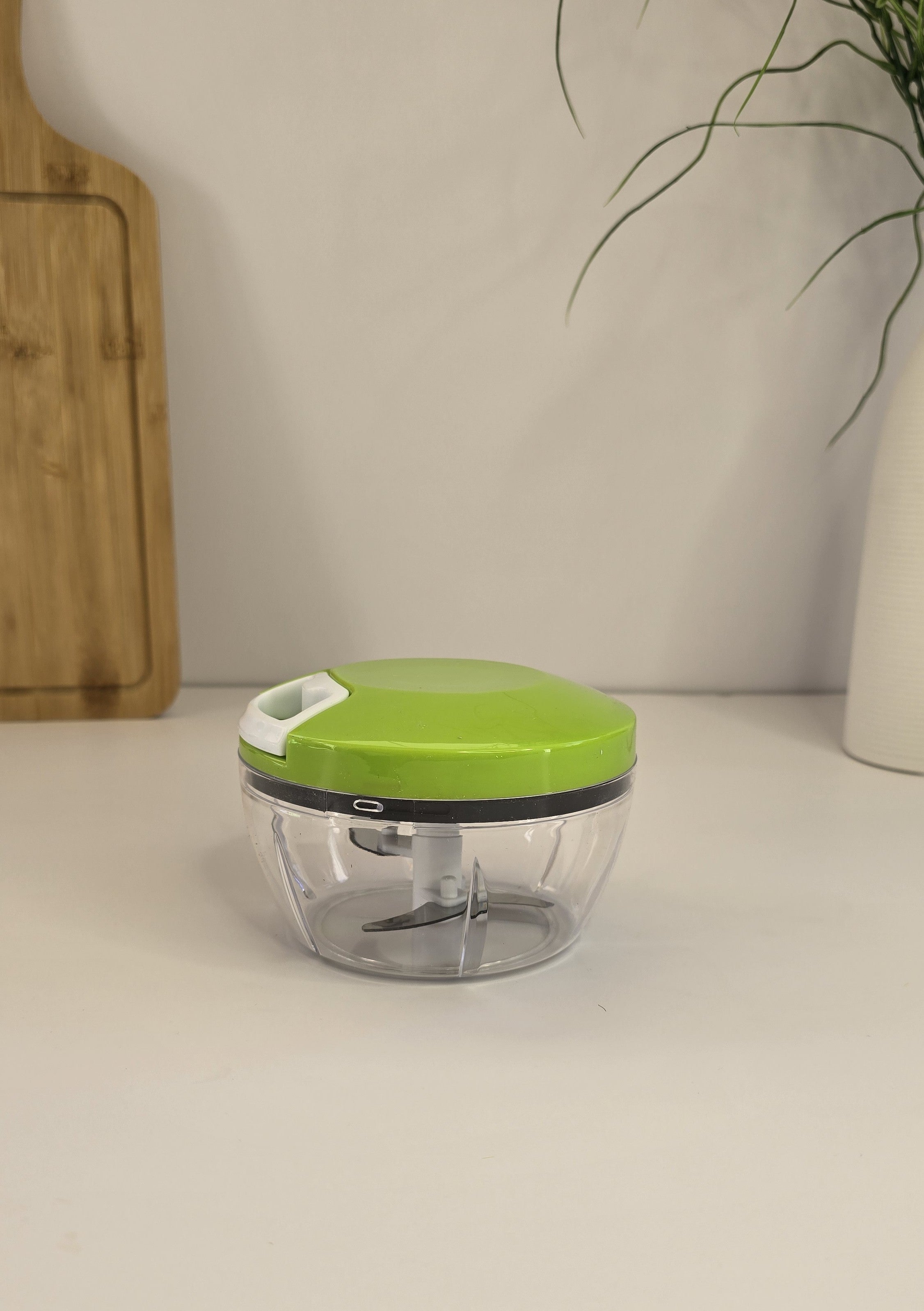 Compact green manual food chopper displayed on a kitchen counter