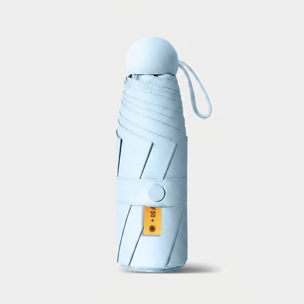 A light blue folded umbrella with a matching carrying loop and a small yellow brand tag, shown on a clean light gray background.