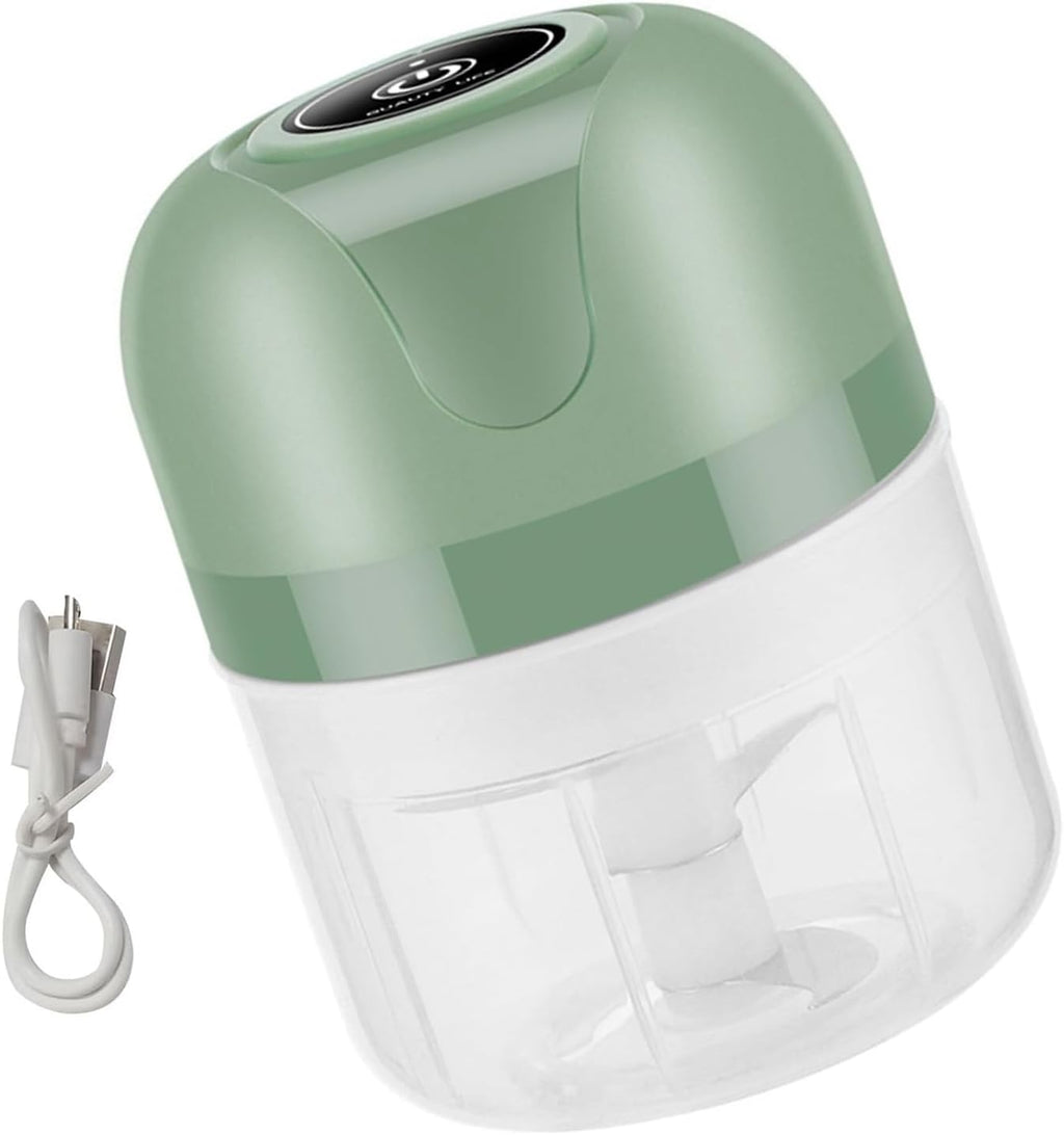A small electric food chopper with a sage green top and a clear plastic container, shown with its white power cord on a white background.