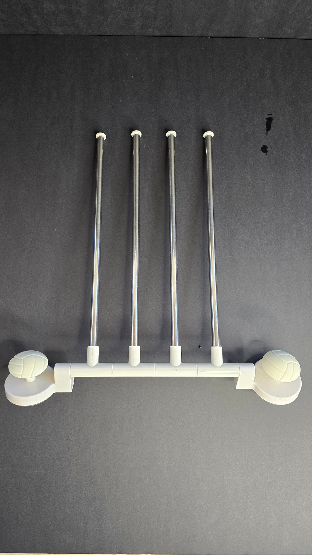White and stainless-steel four-arm rotating towel rack shown flat against a dark background