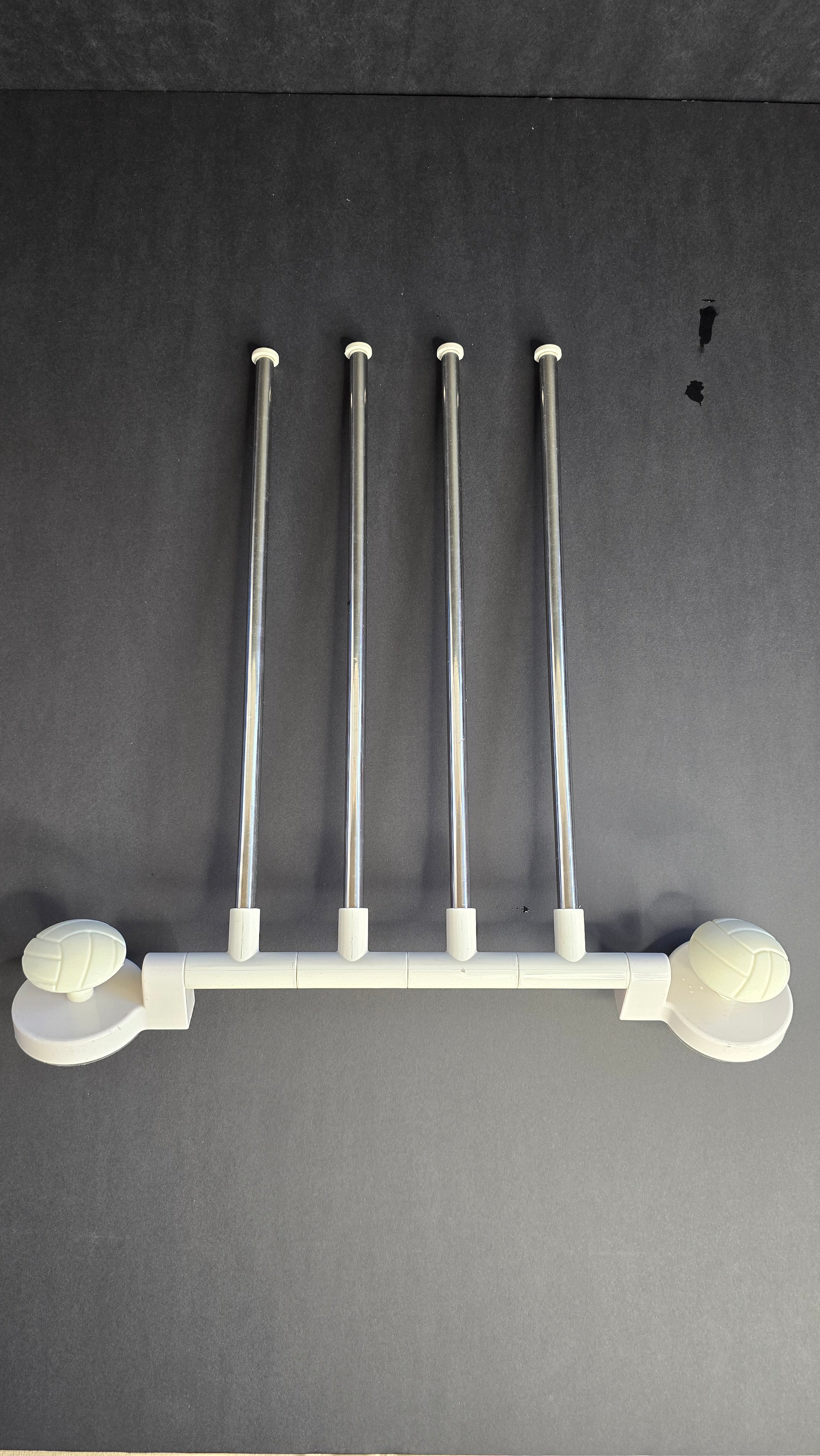 White and stainless-steel four-arm rotating towel rack shown flat against a dark background