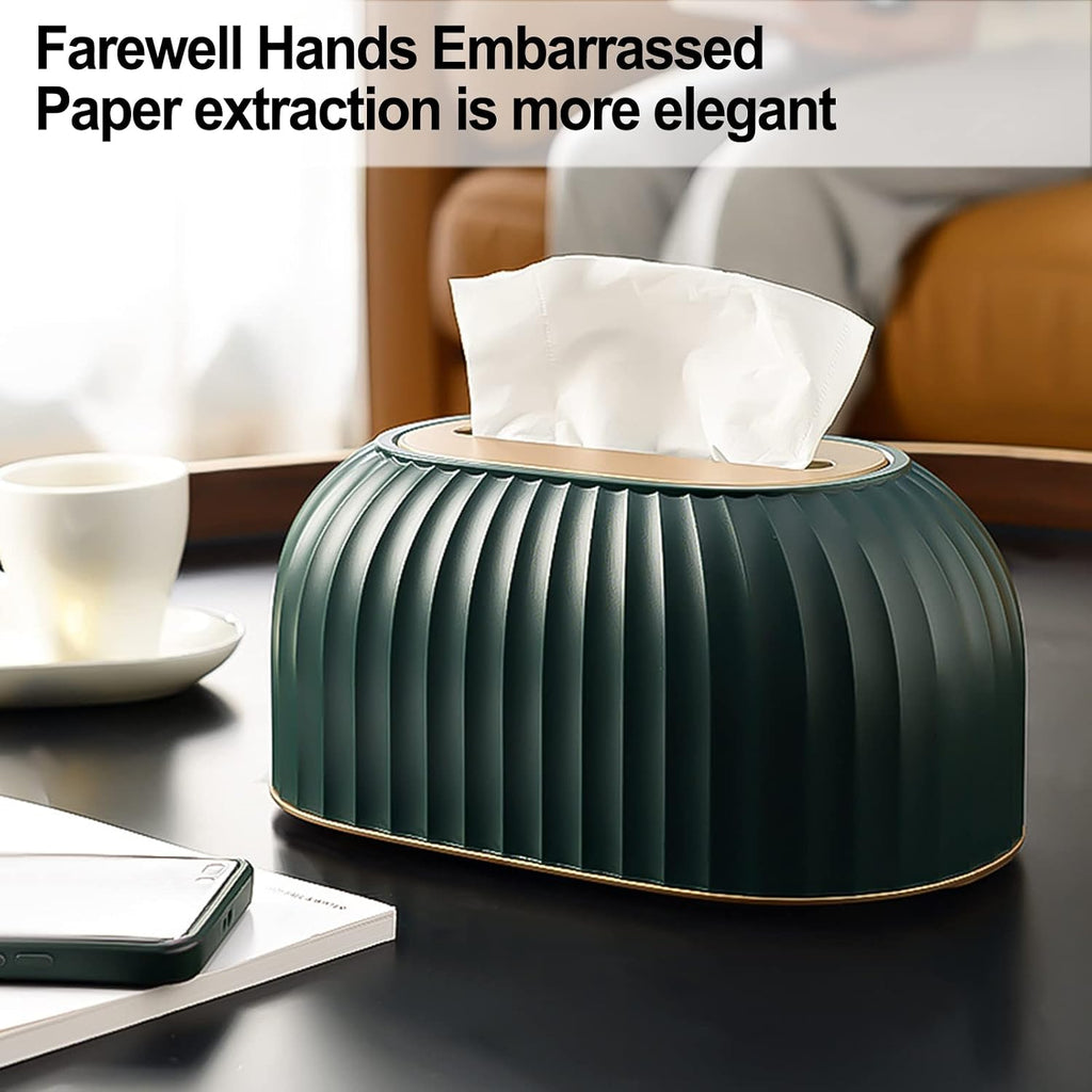 A ribbed dark green tissue box cover with a white tissue protruding, placed on a dark tabletop in a softly lit indoor setting. A white cup, phone, and notebook are visible nearby, and text at the top reads 'Farewell Hands Embarrassed Paper extraction is more elegant.