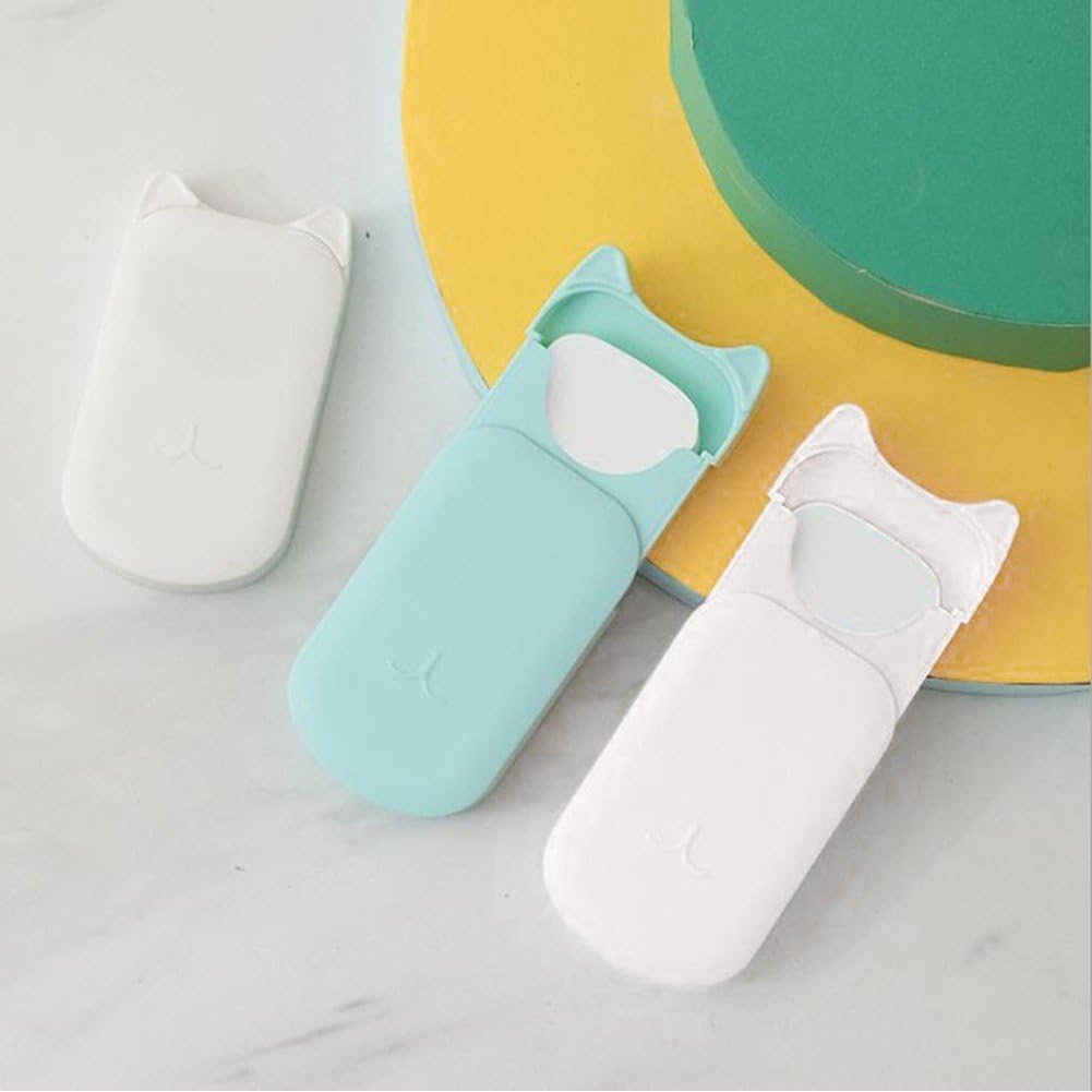 Three cat-shaped dental floss holders in white, mint green, and light blue, arranged on a light marble surface with a yellow and green circular prop in the background.