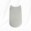 A light gray wireless computer mouse with a subtle cat-ear design on the top, resting on a white fabric background.