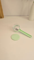 Light green Beiryta vegetable peeler with transparent peel collector shown from the side