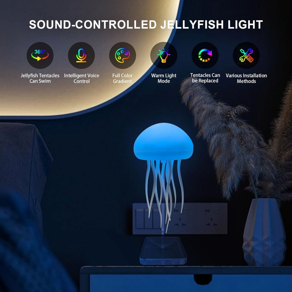 A glowing jellyfish-shaped table lamp on a dark tabletop in a bedroom setting, with a smartphone placed underneath it. The scene includes decorative dried grass and a wall switch, with promotional text at the top reading 'SOUND-CONTROLLED JELLYFISH LIGHT' and feature icons.