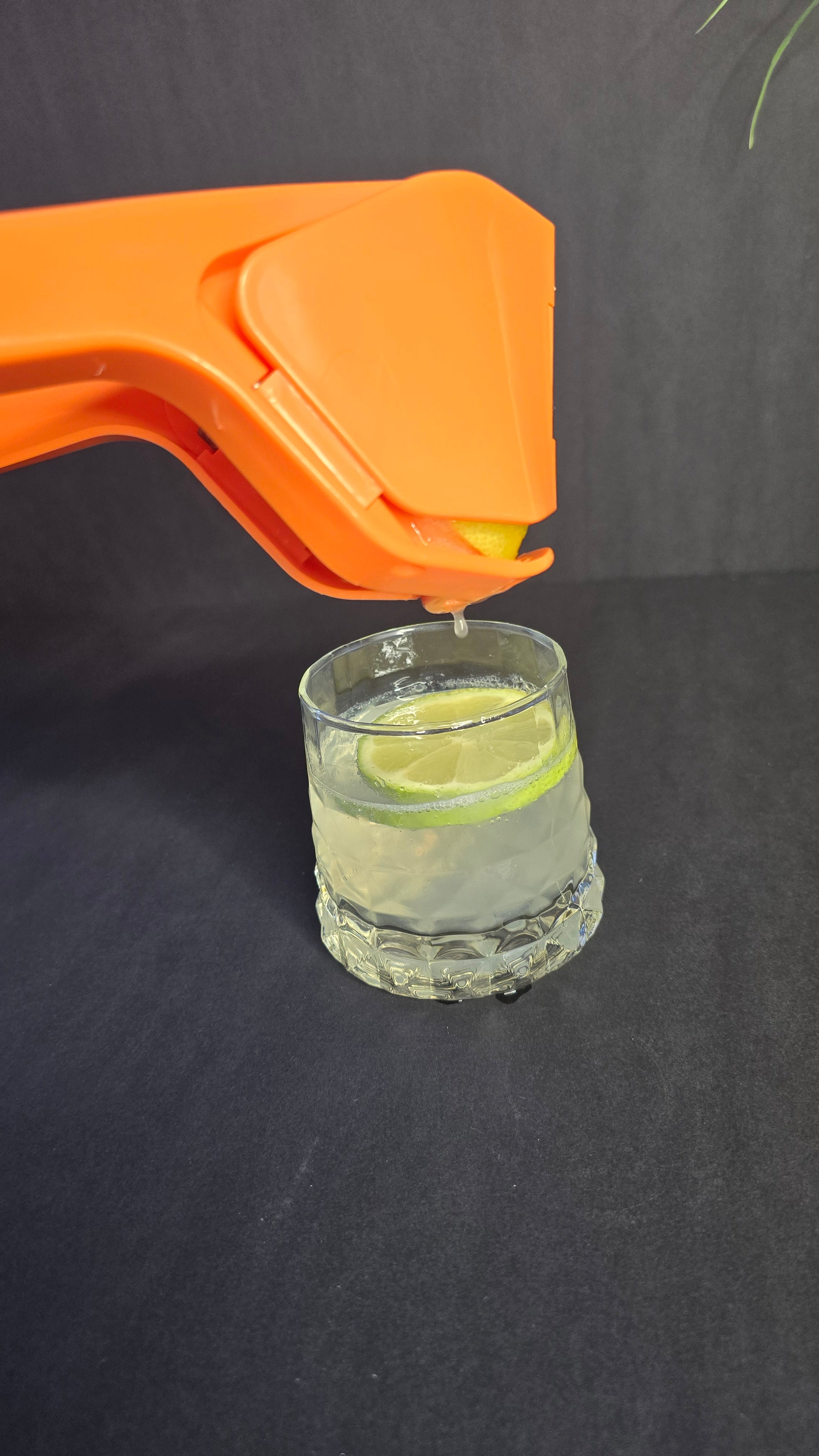 Side view of orange manual citrus juicer
