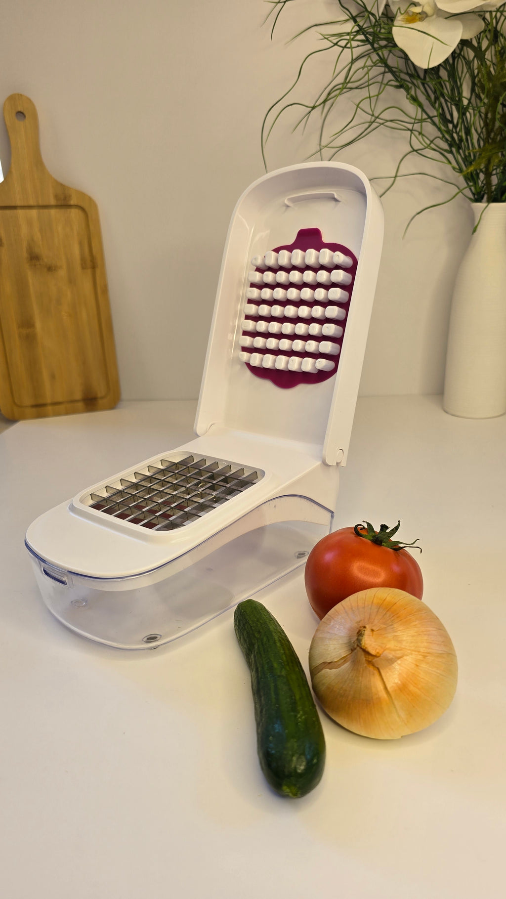 Manual vegetable chopper displayed with onion, cucumber and tomato