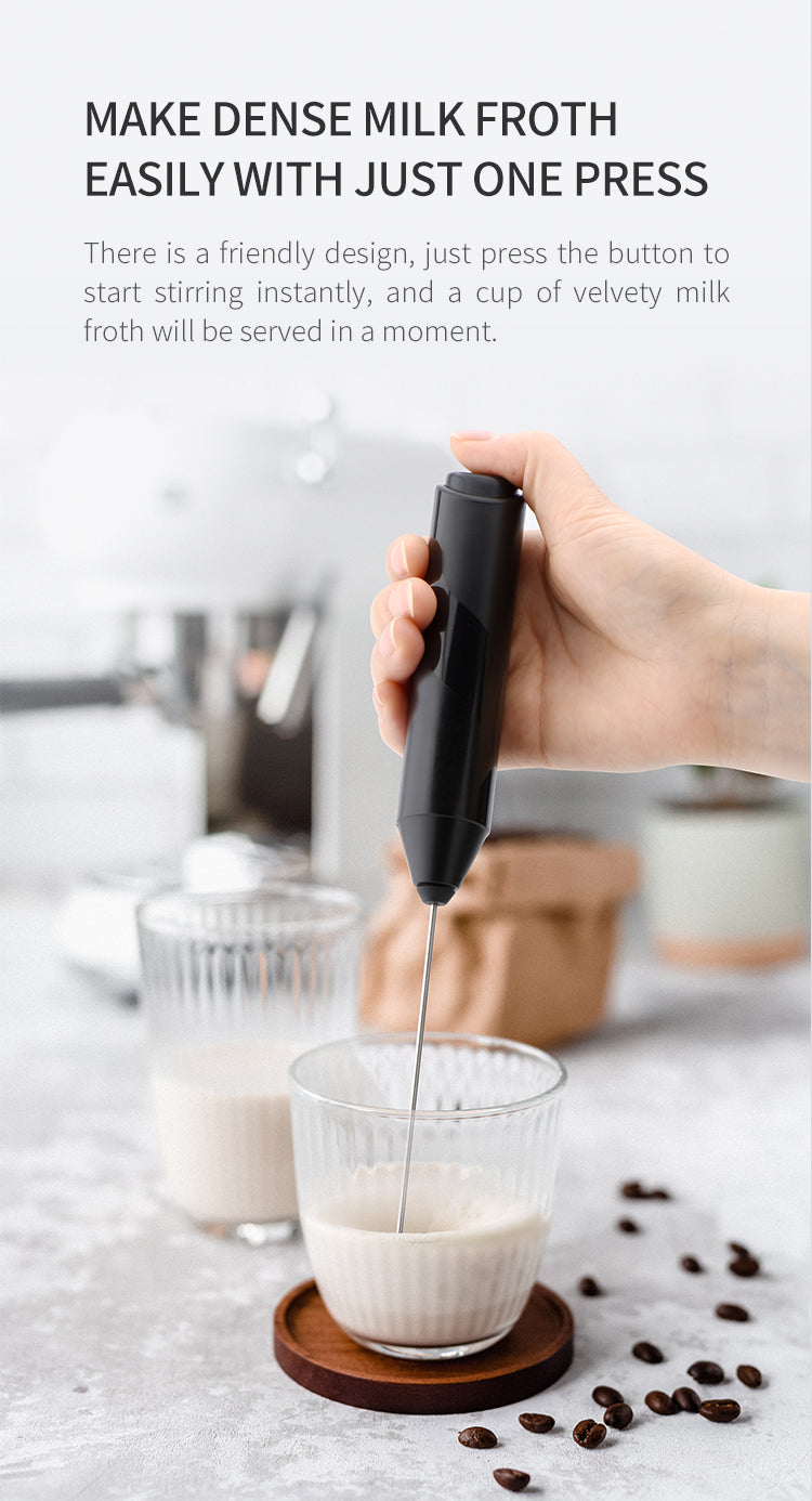 Handheld milk frother mixing milk in a glass using one-button operation