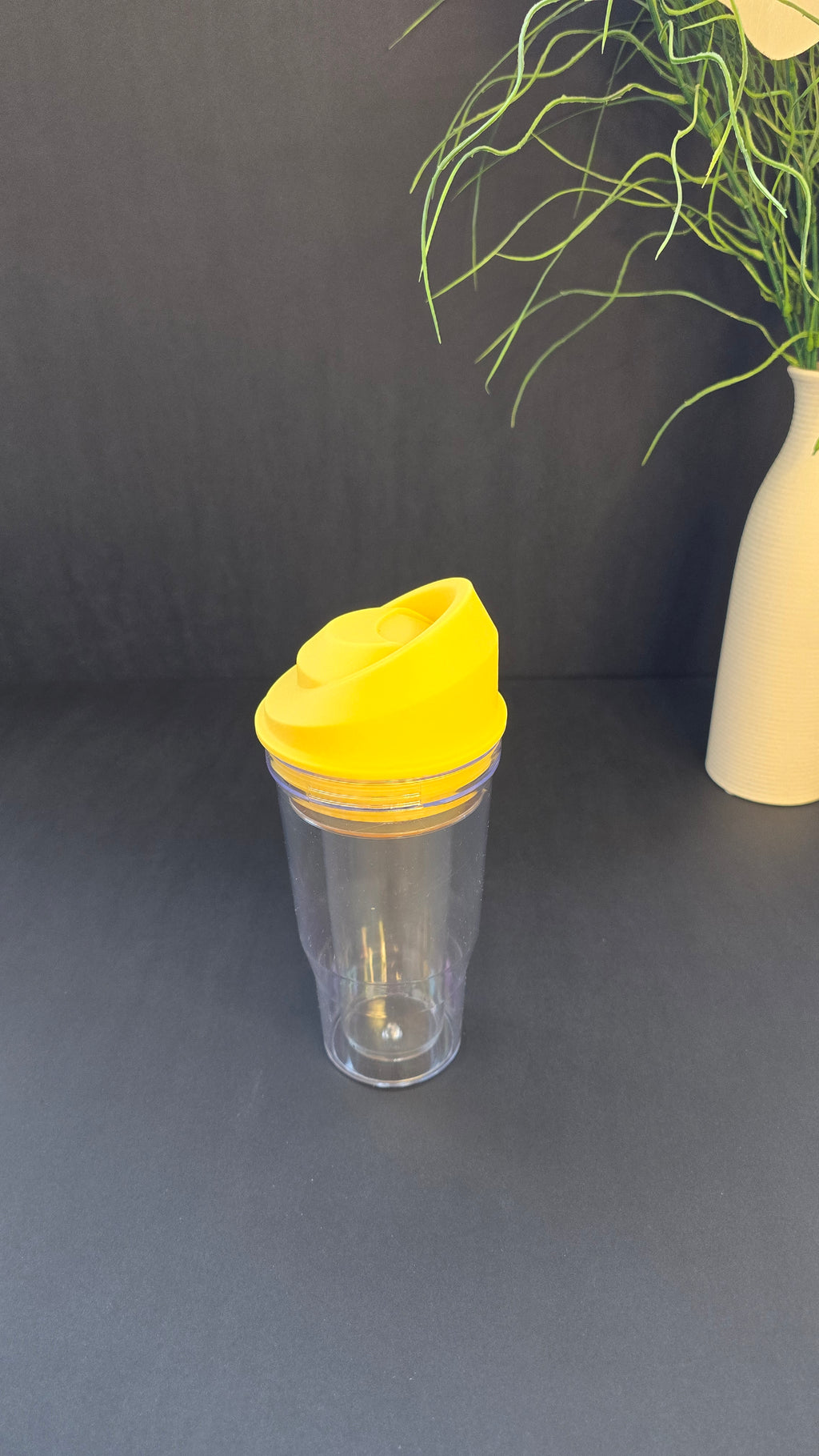 Empty yellow and transparent cereal and milk travel cup