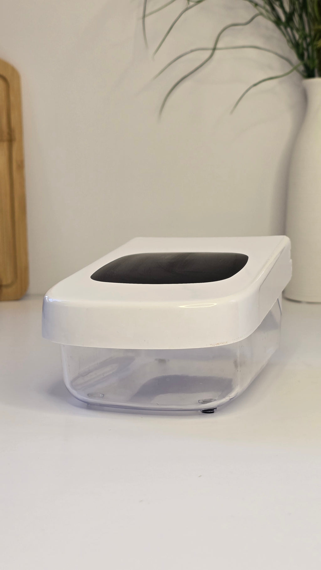Closed white vegetable chopper with transparent collection container