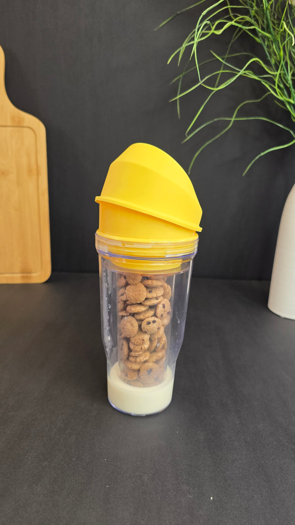 Yellow portable breakfast cup filled with cereal and milk